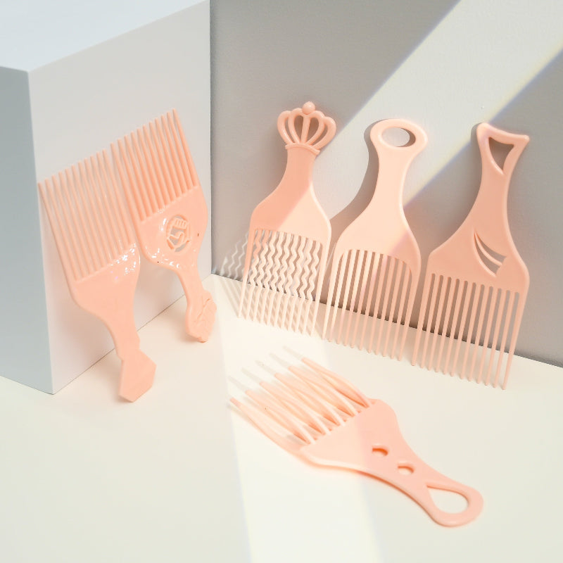 Set of pink hair combs on a light gray background