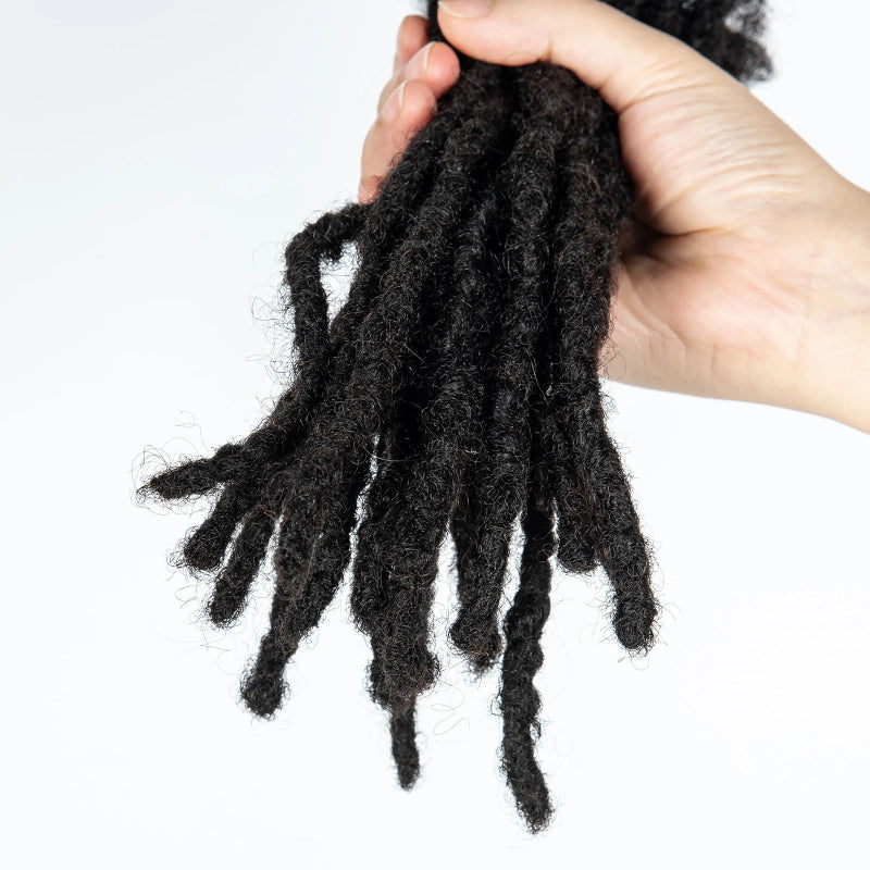 Hand holding a bundle of black synthetic dreadlocks against a white background